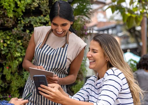 To damer som ser på en telefon