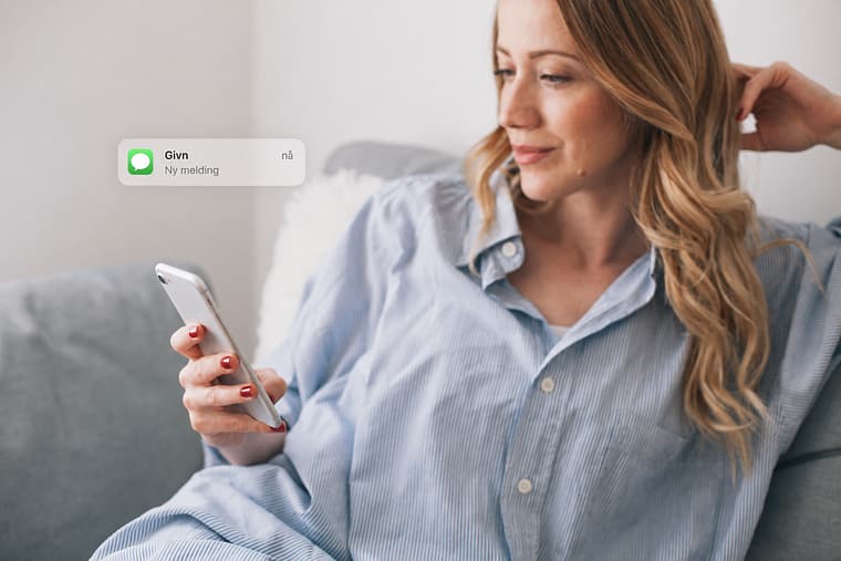A woman receives a text message from Givn on her phone