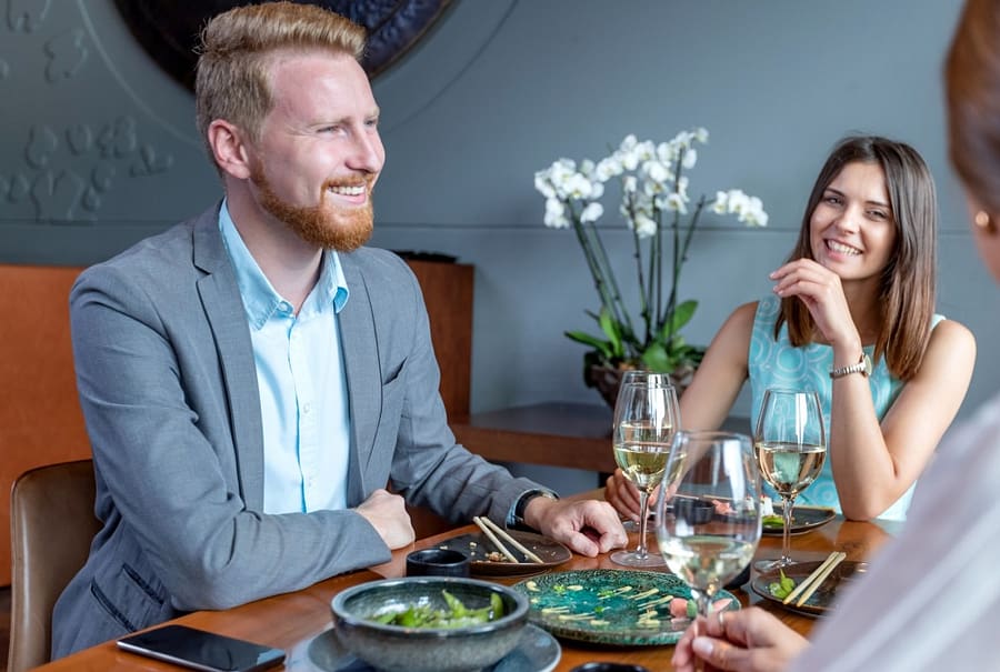 Kollegaer rundt et restaurantbord med bedriftsgaver fra jobben